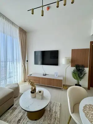 a white living room with a tv and a table at Chic Urban 1br In Jvc With Modern Amenities in Dubai