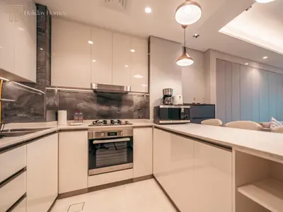 a kitchen with white cabinets and a stove at Stunning One Bed Apartment In Luxury Tower in Dubai