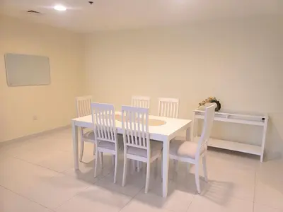 a dining room with a white table and chairs at Damac Park Central - Blue Ocean Holiday Homes in Dubai