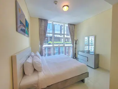 a bedroom with a bed and a large window at Damac Park Central - Blue Ocean Holiday Homes in Dubai