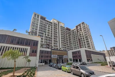 a large building with cars parked in a parking lot at Lux Studio Apt near Butterfly Garden - Pool & Gym in Dubai