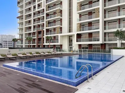 a large swimming pool in front of a building at Lux Studio Apt near Butterfly Garden - Pool & Gym in Dubai