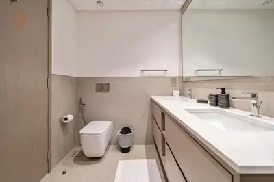 a bathroom with a sink and a toilet and a mirror at Burj Khalifa Views 2-Bedroom Apartment 203GR-2 in Dubai