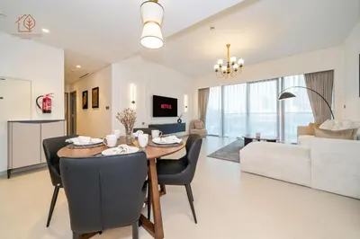 a dining room and living room with a table and chairs at Burj Khalifa Views 2-Bedroom Apartment 203GR-2 in Dubai
