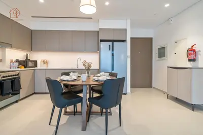 a kitchen and dining room with a table and chairs at Burj Khalifa Views 2-Bedroom Apartment 203GR-2 in Dubai