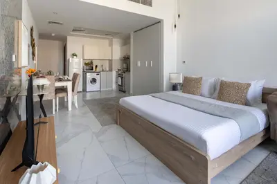 a bedroom with a large bed and a kitchen at Frank Porter - Millennium Binghatti Residences in Dubai