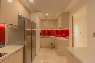 a kitchen with red cabinets and a stainless steel refrigerator at Luxury 3BR Stunning Burj Khalifa View in Dubai