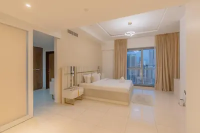 a white bedroom with a bed and a large window at Luxury 3BR Stunning Burj Khalifa View in Dubai
