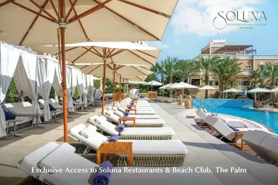 a row of lounge chairs and umbrellas next to a pool at Grand Millennium Business Bay in Dubai