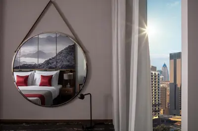 a mirror in a room with a bed and a window at Grand Millennium Business Bay in Dubai
