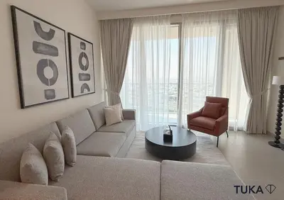 a living room with a couch and a table and a chair at 2BR Forte Tower 1 Downtown 3mn Burj Khalifa in Dubai