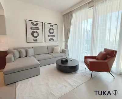 a living room with a couch and a chair at 2BR Forte Tower 1 Downtown 3mn Burj Khalifa in Dubai