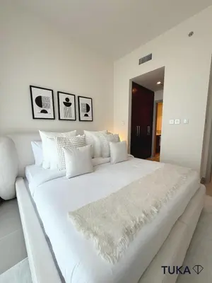 a white bedroom with a large white bed with white pillows at 2BR Forte Tower 1 Downtown 3mn Burj Khalifa in Dubai