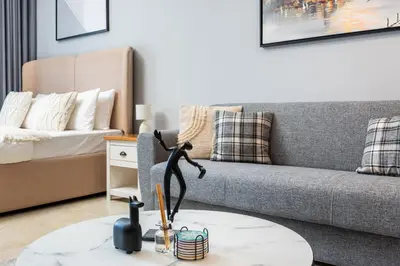 a living room with a couch and a table at Chic Studio in Goldcrest Views, JLT in Dubai