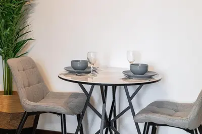 a round table with two chairs and wine glasses at Chic Studio in Goldcrest Views, JLT in Dubai