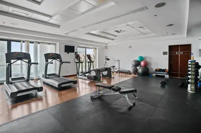 a gym with several treadmills and machines in a room at Chic Studio in Goldcrest Views, JLT in Dubai