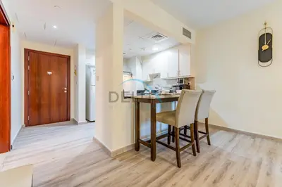 a kitchen with a table and chairs in a room at Lovely Studio in Murjan 2, Jumeirah Beach Residence by Deluxe Holiday Homes in Dubai