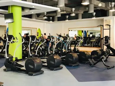 a gym with cardio equipment and people exercising in it at Lovely Studio in Murjan 2, Jumeirah Beach Residence by Deluxe Holiday Homes in Dubai