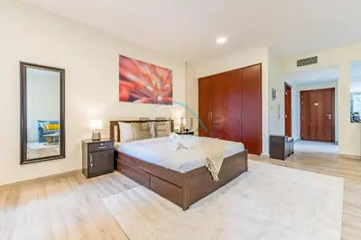 a bedroom with a large bed and a large mirror at Lovely Studio in Murjan 2, Jumeirah Beach Residence by Deluxe Holiday Homes in Dubai