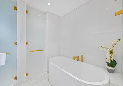 a white bathroom with a tub and a toilet at Daniels Sea View 2BR at Five Palm Jumeirah in Dubai