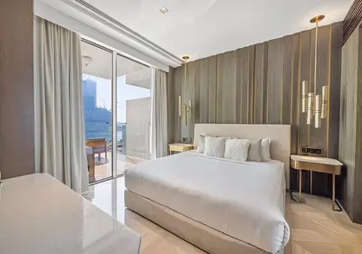 a bedroom with a large white bed and a balcony at Daniels Sea View 2BR at Five Palm Jumeirah in Dubai