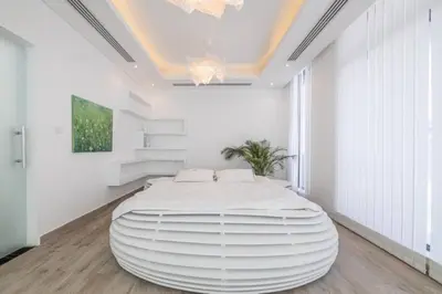 a large white bedroom with a large white bed at Coastal Themed 4BR Townhouse with Pool in JVC in Dubai