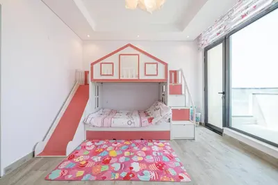 a childs bedroom with a bunk bed and a rug at Coastal Themed 4BR Townhouse with Pool in JVC in Dubai