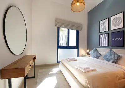 a bedroom with a large bed and a mirror at Breathtaking Villa With Roof Garden and Beach access in Dubai