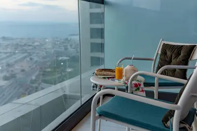 a balcony with a table with food and drinks on it at Stunning 3BR w Panoramic Views in Aykon City in Dubai