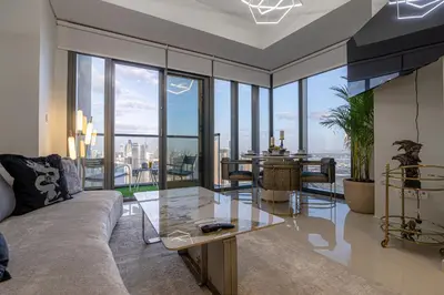 a living room with a couch and a table at Stunning 3BR w Panoramic Views in Aykon City in Dubai