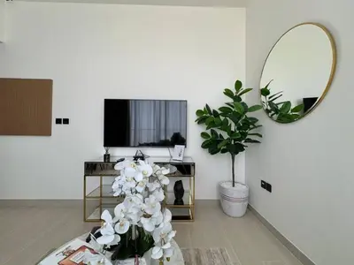 a living room with a plant and a mirror at Trendy & Elegant 1br In Jvc in Dubai