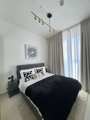 a bedroom with a black and white bed and a window at Trendy & Elegant 1br In Jvc in Dubai