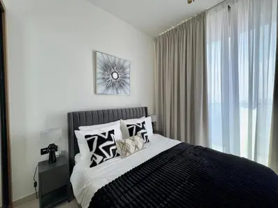 a bedroom with a bed with black and white pillows at Trendy & Elegant 1br In Jvc in Dubai