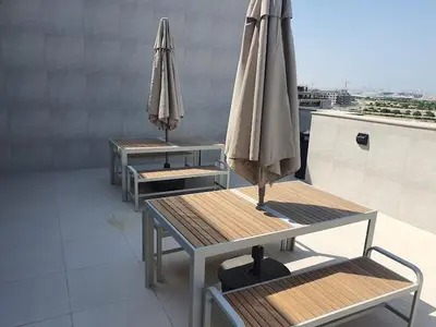 three tables with umbrellas on top of a building at Elegant 2-Bedroom Apartment with Private Balconies & En-Suite Luxury in Meydan Avenue in Dubai