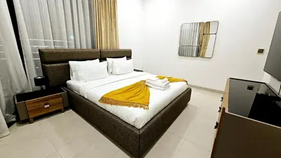 a bedroom with a bed with a yellow blanket on it at Elegant 2-Bedroom Apartment with Private Balconies & En-Suite Luxury in Meydan Avenue in Dubai