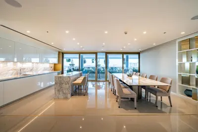 an open kitchen and dining room with a table and chairs at Homes Beyond l Elegant 2BR with Wide Sea Views in Dubai