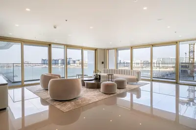 a living room with a lot of windows at Homes Beyond l Elegant 2BR with Wide Sea Views in Dubai