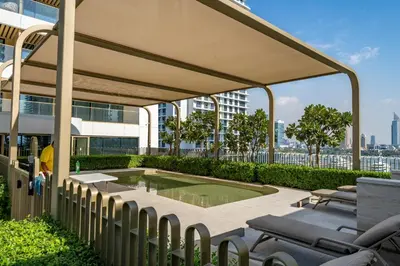 a patio with chairs and a pool on top of a building at Homes Beyond l 2BR Panoramic Skyline & Sea View in Dubai