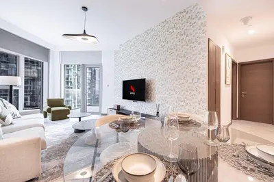 a living room with a glass table and a couch at Mahogany 2 - 2BR 6PAX - Infinity Pool & Near Metro in Dubai