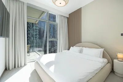 a bedroom with a white bed and a large window at Mahogany 2 - 2BR 6PAX - Infinity Pool & Near Metro in Dubai