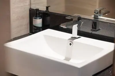 a white sink in a bathroom with a mirror at Mahogany 2 - 2BR 6PAX - Infinity Pool & Near Metro in Dubai