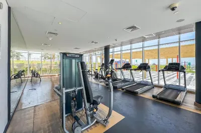 a gym with rows of treadmills and ellipticals at Modern 1-BR Golf Course View in Golf Vita in Dubai