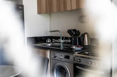 a kitchen with a sink and a washing machine at Modern 1-BR Golf Course View in Golf Vita in Dubai