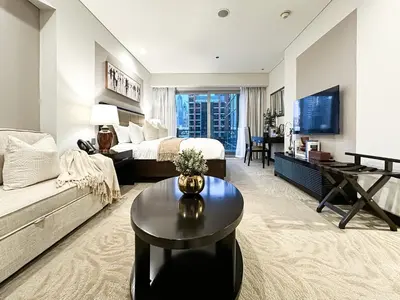 a bedroom with a bed and a couch and a table at Trophy - Marina Address Studio - Full Marina View in Dubai