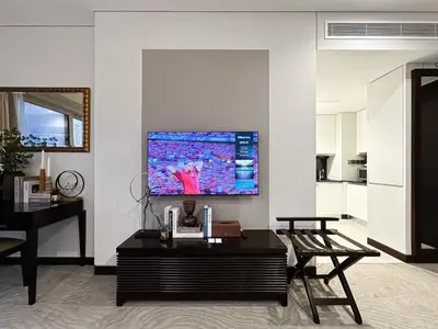 a living room with a table and a tv on a wall at Trophy - Marina Address Studio - Full Marina View in Dubai