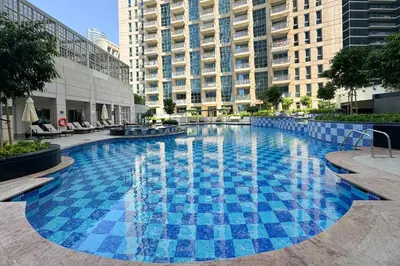 a large swimming pool in a city with tall buildings at Sophisticated and Elegant 2BR in Downntown Dubai in Dubai
