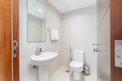 a white bathroom with a toilet and a sink at Sophisticated and Elegant 2BR in Downntown Dubai in Dubai