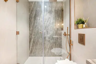 a shower with a glass door in a bathroom at FIRST CLASS Studio Stylish Living in Dubai