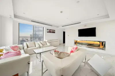 a living room with white furniture and a flat screen tv at Elegant 2BR with Burj Views, Pool, Gym, and Quick Metro Access in Dubai