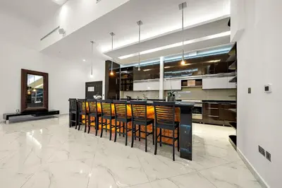 a large kitchen with a bar with stools at Elegant 2BR with Burj Views, Pool, Gym, and Quick Metro Access in Dubai